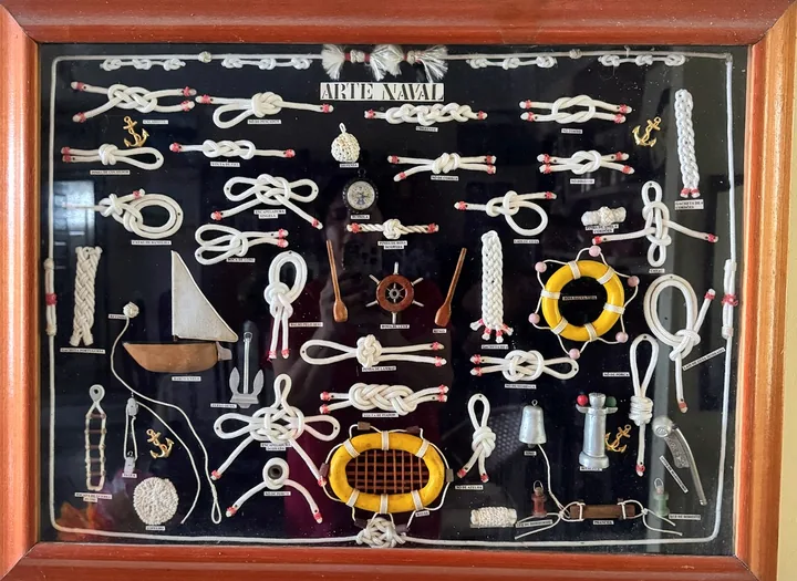 Board of sailor's knots mounted on a dark background in a wooden frame