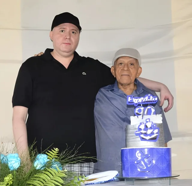 Emerson and his father, Expedito, arm in arm beside a cake decorated with an anchor